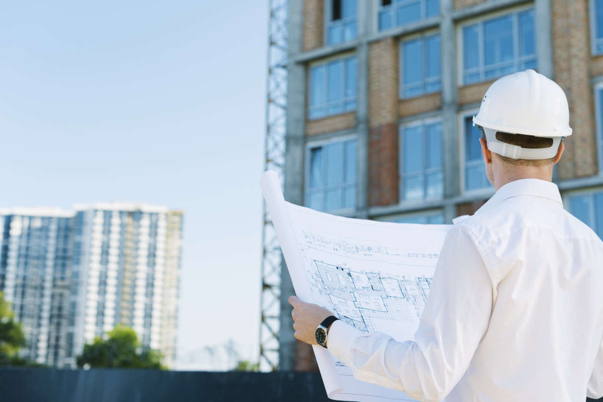 Back view man holding building plans